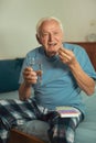 Senior Man Sitting On Bed Taking Medication Royalty Free Stock Photo