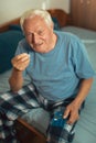 Senior Man Sitting On Bed Taking Medication Royalty Free Stock Photo