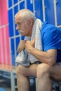 senior man sitting in fitness club locker room after workout Royalty Free Stock Photo