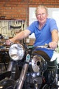 Senior Man Sitting On Restored Vintage Motorcycle Royalty Free Stock Photo