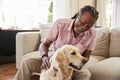 Senior Man Sitting On Sofa At Home With Pet Labrador Dog Royalty Free Stock Photo