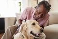 Senior Man Sitting On Sofa At Home With Pet Labrador Dog Royalty Free Stock Photo