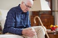 Senior Man Sitting On Sofa At Home Suffering With Knee Pain From Arthritis Royalty Free Stock Photo