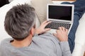 Senior man sitting in sofa and using laptop Royalty Free Stock Photo