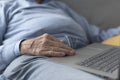 Senior man sitting on the sofa and using a laptop Royalty Free Stock Photo