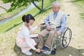 Senior man sitting on a wheelchair with caregiver Royalty Free Stock Photo