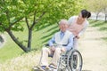 Senior man sitting on a wheelchair with caregiver Royalty Free Stock Photo