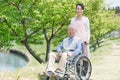 Senior man sitting on a wheelchair with caregiver Royalty Free Stock Photo