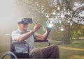 Senior man sitting on wheelchair using virtual reality headset and network connecting icons