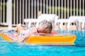 Senior man sleep and enjoy the relax summer holiday vacation lay down on a coloured lilo at the pool- concept of mature people and