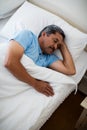 Senior man sleeping on bed in bedroom Royalty Free Stock Photo