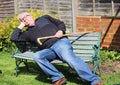 Senior man sleeping on park bench.