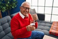 Senior man smiling confident taking pill at home Royalty Free Stock Photo