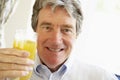 Senior Man Smiling And Drinking Orange Juice Royalty Free Stock Photo