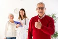 Senior man smiling with his wife and doctor in background Royalty Free Stock Photo