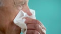 senior man sneezing in napkin having allergy, elderly with allergic rhinitis suffering from nasal problem and sinusitis