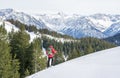 Senior man is snowshoe hiking in alpine snow winter mountains. Allgau, Bavaria, Germany. Royalty Free Stock Photo