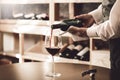 Sommelier Concept. Senior man standing pouring wine into glass elegant close-up