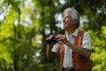 Senior man spending free time outdoors in nature, watching forest animals through binoculars. Royalty Free Stock Photo