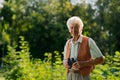 Senior man spending free time outdoors in nature, watching forest animals through binoculars. Royalty Free Stock Photo