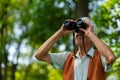 Senior man spending free time outdoors in nature, watching forest animals through binoculars. Royalty Free Stock Photo