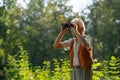 Senior man spending free time outdoors in nature, watching forest animals through binoculars. Royalty Free Stock Photo