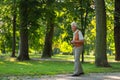 Senior man spending free time outdoors in nature, watching forest animals through binoculars. Royalty Free Stock Photo