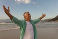 Senior man standing with arms outstretched on the beach Royalty Free Stock Photo