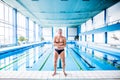 Senior man standing by the indoor swimming pool. Royalty Free Stock Photo