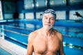 Senior man standing in an indoor swimming pool. Royalty Free Stock Photo