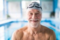 Senior man standing in an indoor swimming pool. Royalty Free Stock Photo