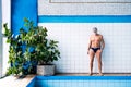 Senior man standing by the indoor swimming pool. Royalty Free Stock Photo