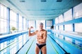 Senior man standing by the indoor swimming pool. Royalty Free Stock Photo