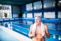 Senior man standing by the indoor swimming pool. Royalty Free Stock Photo