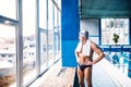 Senior man standing in an indoor swimming pool. Royalty Free Stock Photo