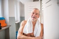 Senior man standing by the lockers in an indoor swimming pool. Royalty Free Stock Photo