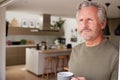 Senior Man Standing And Looking Out Of Kitchen Door Drinking Coffee Royalty Free Stock Photo