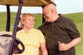 Senior man standing near his wife in cart Royalty Free Stock Photo