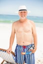 Senior man standing next to sunchair Royalty Free Stock Photo