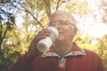 Senior man standing in park and drinking coffee after ex Royalty Free Stock Photo