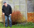 Senior man standing using a stick for support.. Royalty Free Stock Photo