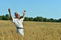 Senior man standing on wheat field with cloudy sky on background Royalty Free Stock Photo