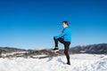 Senior man stretching before the run in winter nature. Copy space. Royalty Free Stock Photo