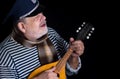 Senior man in striped vest and comforter with mandolin Royalty Free Stock Photo