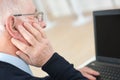 Senior man suffering from deafness with computer