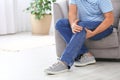 Senior man suffering from knee pain at home, closeup. Royalty Free Stock Photo