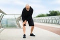 Senior man suffering with knee pain during workout outdoor Royalty Free Stock Photo