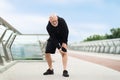 Senior man suffering with knee pain during workout Royalty Free Stock Photo