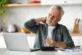 Senior Man Suffering Neckache While Working With Laptop In Kitchen Interior Royalty Free Stock Photo