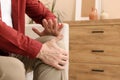 Senior man suffering from pain in his knee at home, closeup. Arthritis symptoms Royalty Free Stock Photo